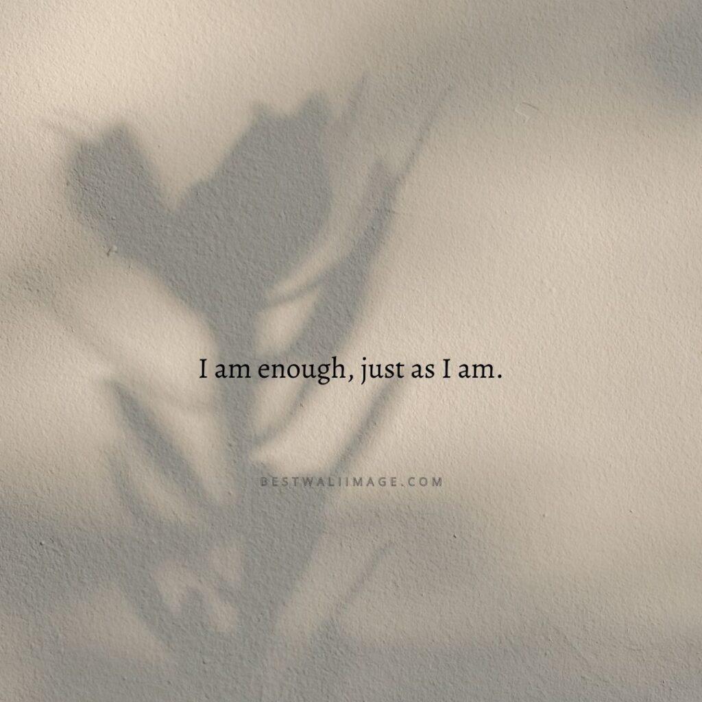 A piece of gray paper with the words _I am enough, just as I am_ written in black ink